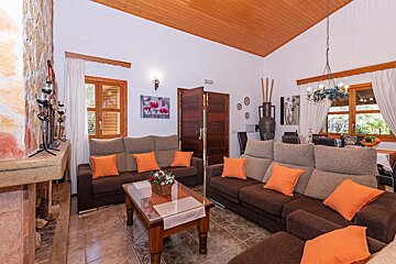 A living room with a brown couch and orange pillows