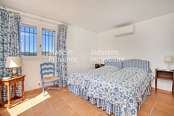 A bedroom with two beds made in provence by immobilier