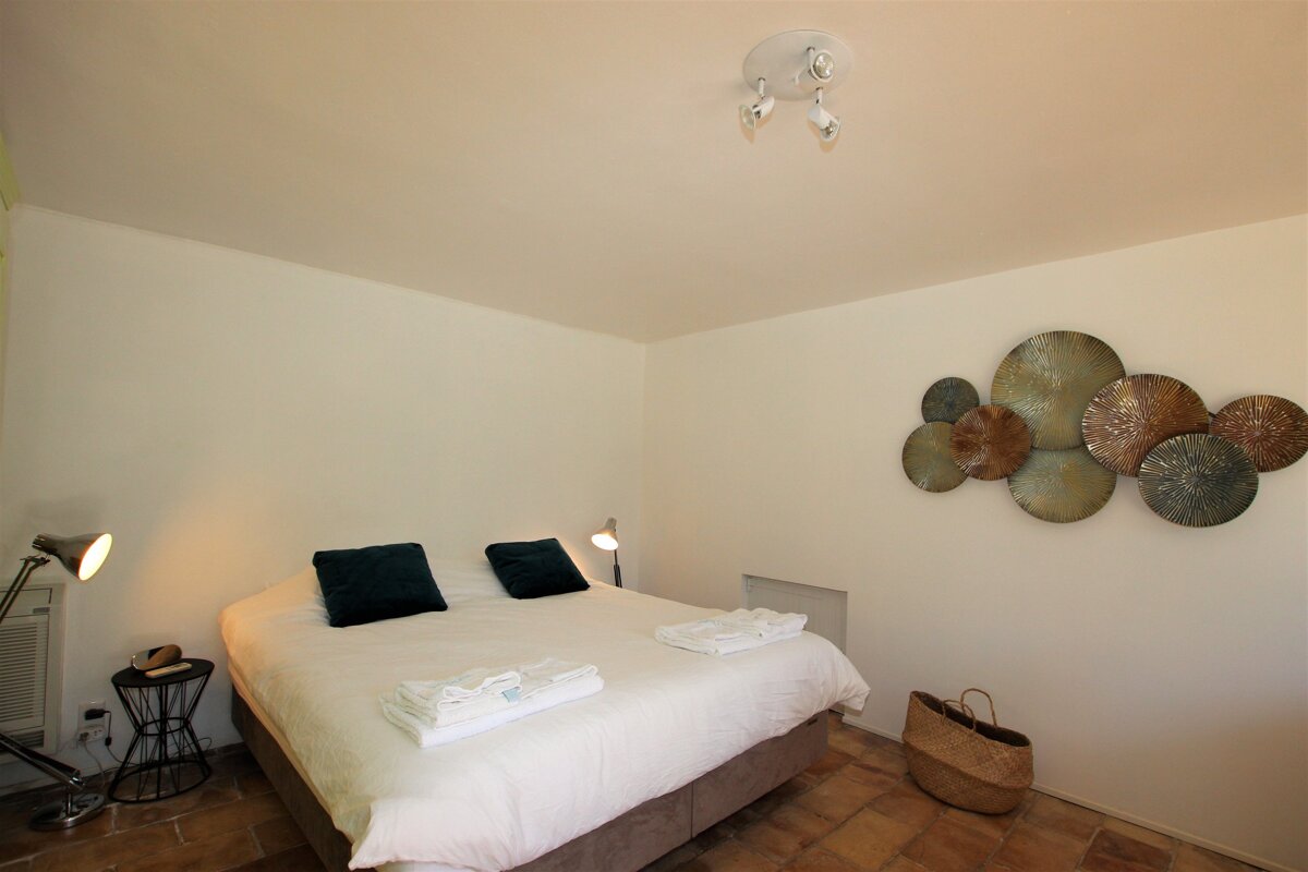 A bedroom with a large bed and a basket on the floor