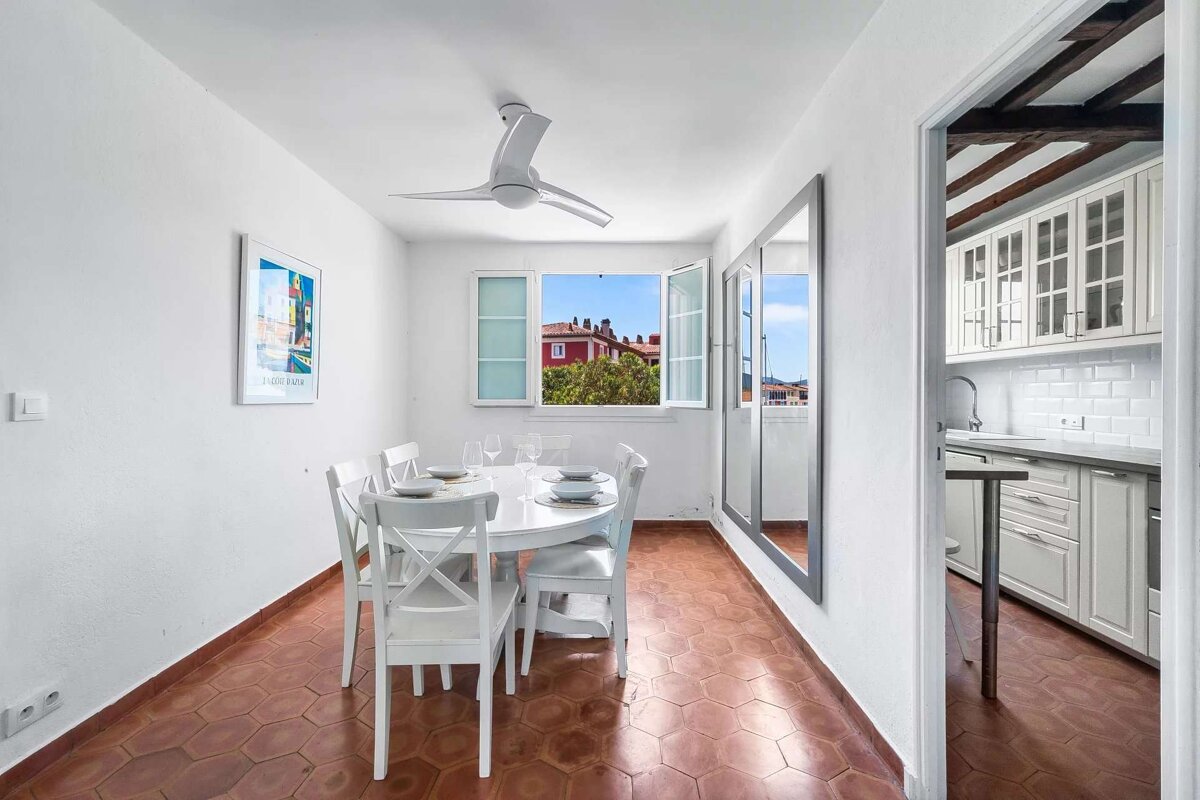 A dining room with a table and chairs and a ceiling fan