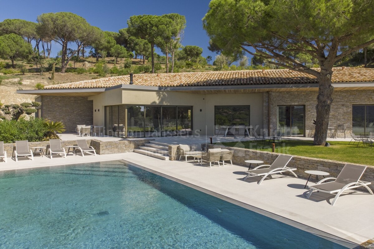 A large house with a swimming pool in front of it