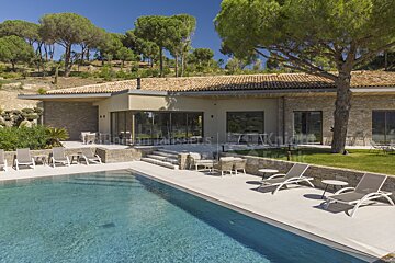 A large house with a swimming pool in front of it