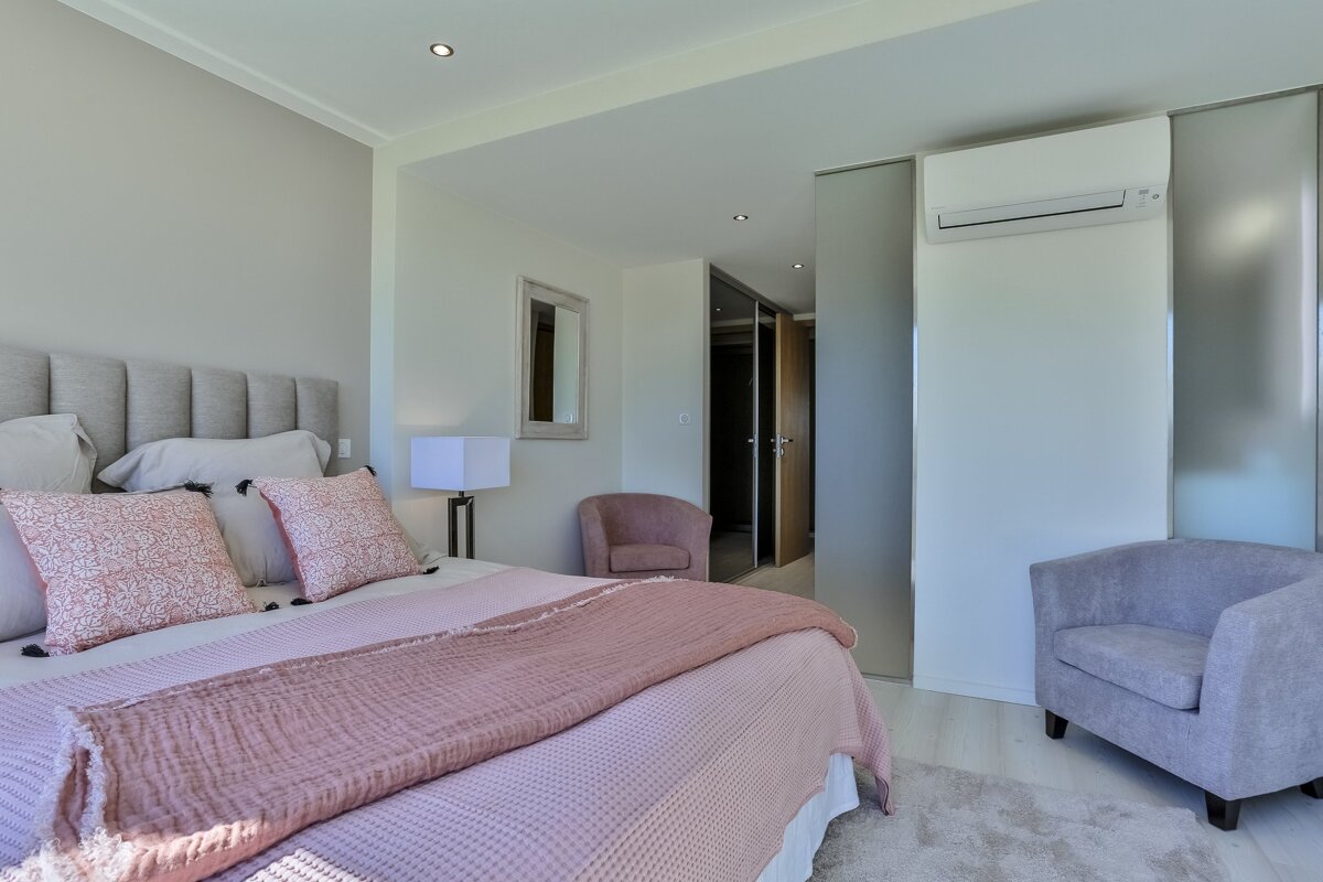 A bedroom with a large bed and a chair