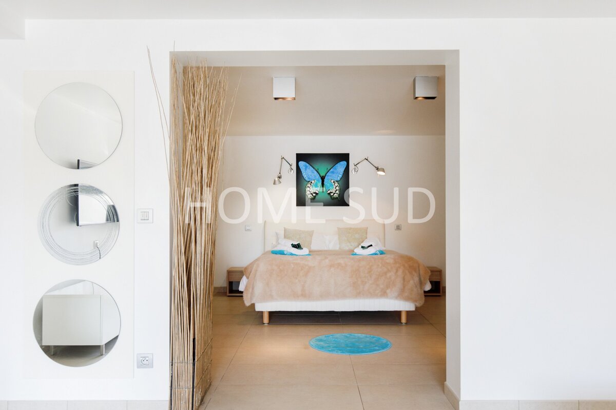 A bedroom with a painting of a butterfly and the word homesud on the wall