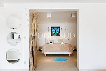 A bedroom with a painting of a butterfly and the word homesud on the wall