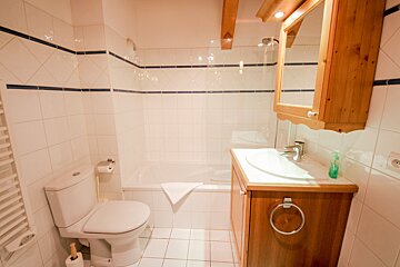 A bathroom with a toilet a sink and a bathtub