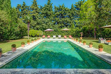 A large swimming pool surrounded by chairs and umbrellas