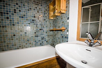 A bathroom with blue tiles and a sink