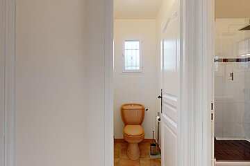 A bathroom with a toilet and a window