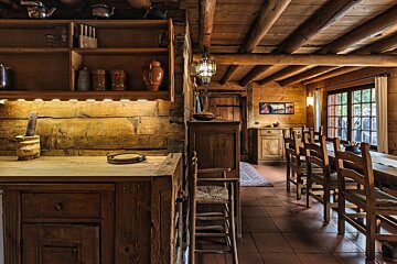 A wooden dining room with a table and chairs