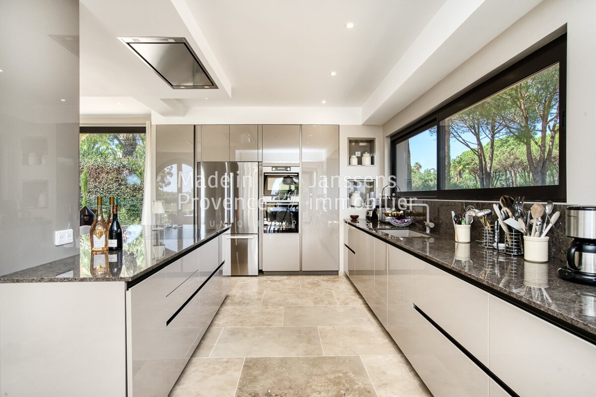 A kitchen with a few bottles of wine on the counter