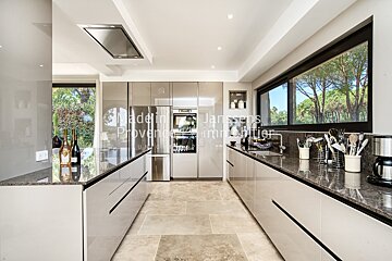 A kitchen with a few bottles of wine on the counter