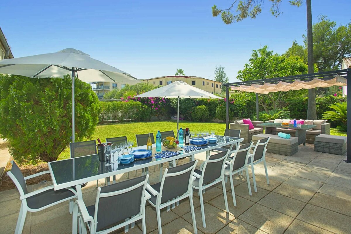 A patio with a table and chairs and umbrellas