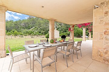 A patio with a table and chairs and a grill