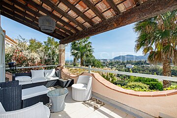 A balcony with a view of mountains and palm trees