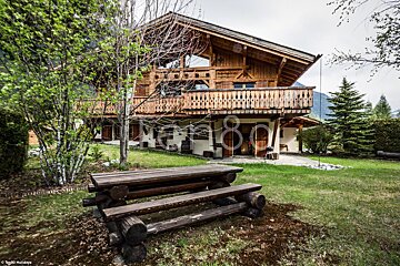 A large wooden house with a picnic table in front of it