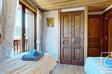 A bedroom with two beds and a painting on the wall