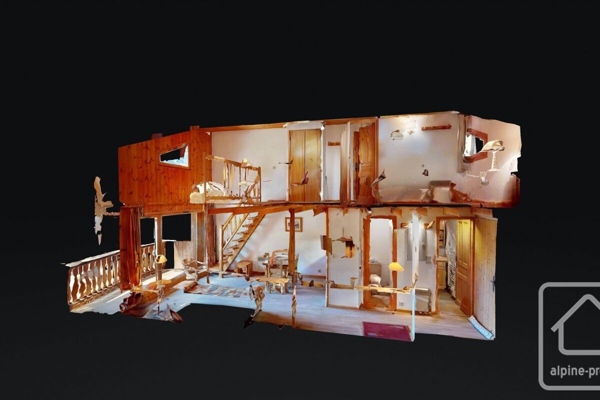 A detailed 3D cut-away model of a two-story rustic house interior, revealing rooms, wooden stairs, and furnishings on a dark background.
