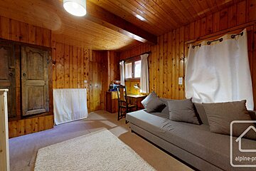 A wooden room with a couch and a sign that says alpine-pr