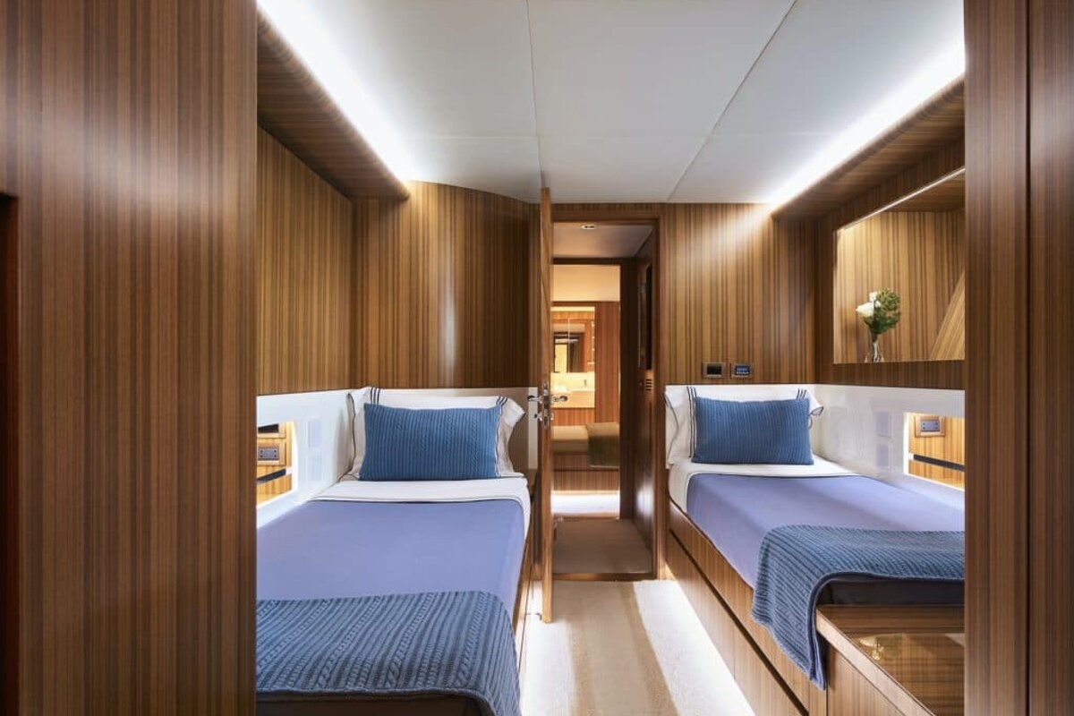 A bedroom with two beds and a mirror