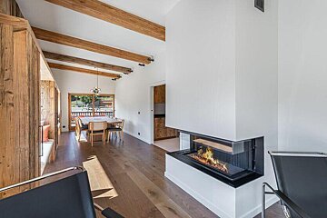 A living room with a fireplace and wooden beams