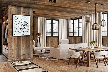 A chic rustic modern living and dining room with extensive warm wood paneling, large windows, and contemporary furniture. A ski art print adorns the wall.