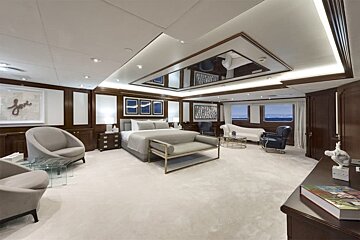 A large bedroom with a large mirrored ceiling