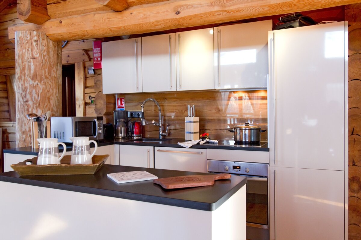 A kitchen with white cabinets and a red fire exit sign
