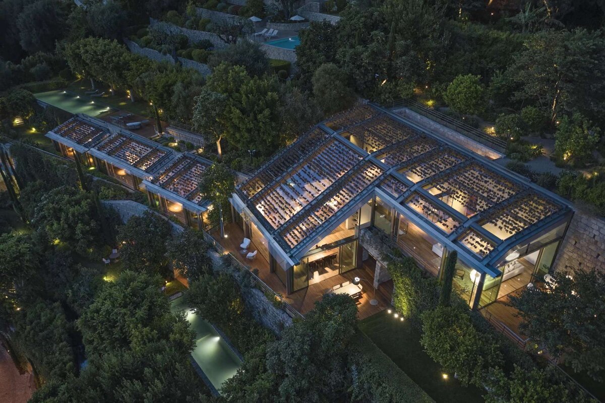 An aerial view of a house surrounded by trees and a pool