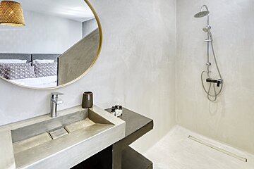 A bathroom with a sink a mirror and a shower