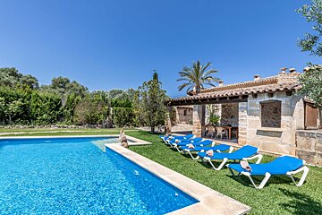A row of blue lounge chairs sit next to a swimming pool