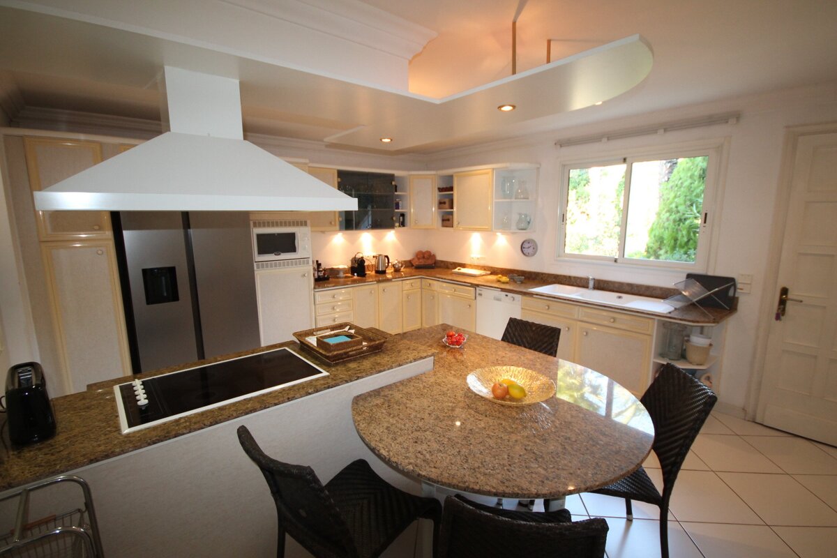 A kitchen with a stove top oven and a refrigerator