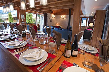 A bottle of wine sits on a wooden table