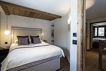 A bedroom with a king size bed and a wooden ceiling