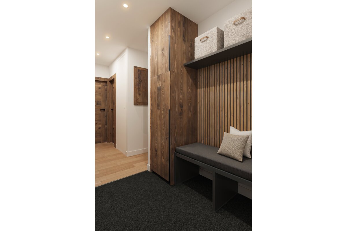 A hallway with wooden cabinets and a bench