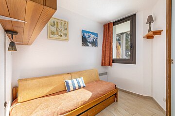 A room with a couch and a painting on the wall