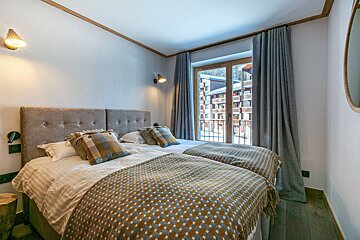 A bedroom with a bed and a bathroom with a sink