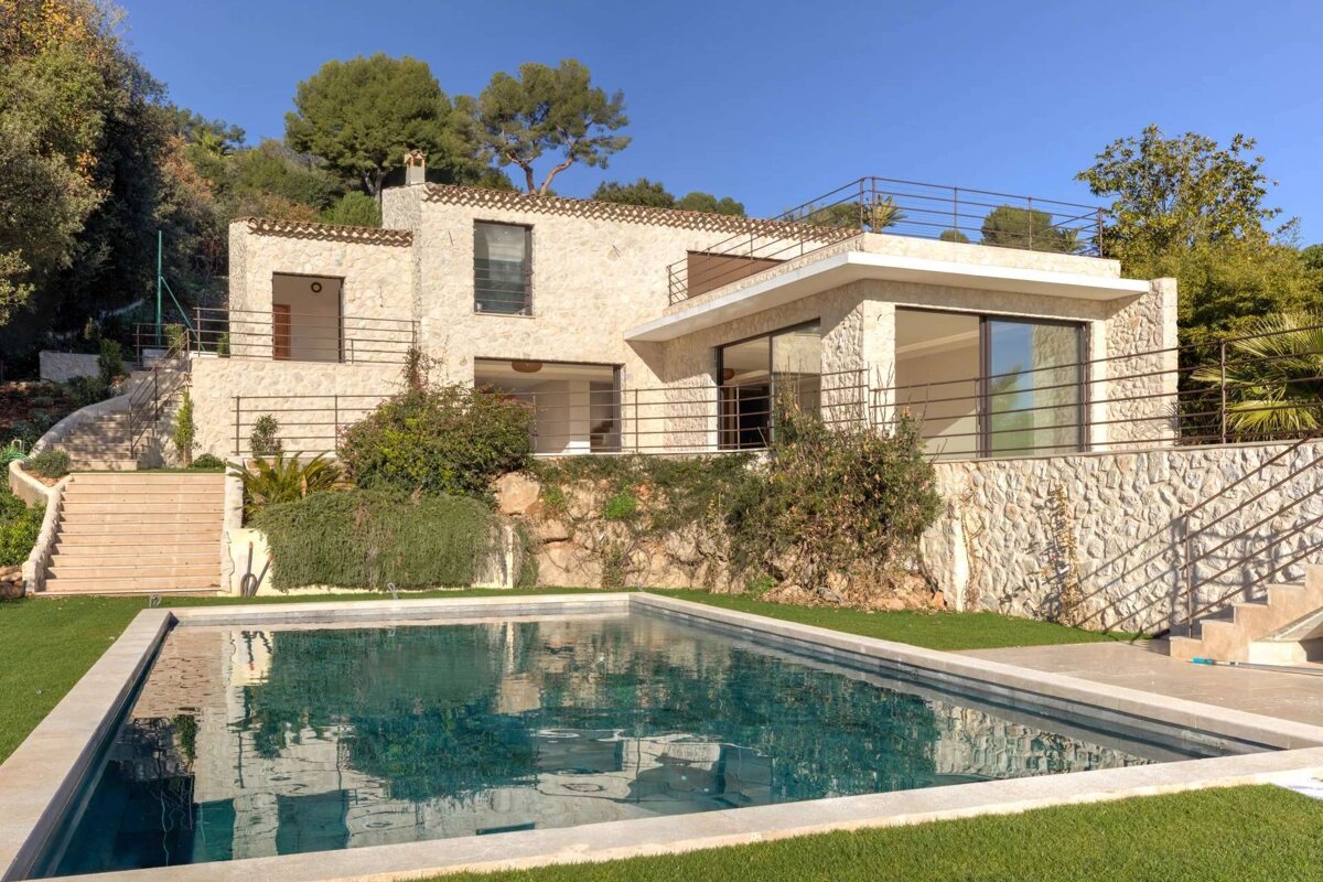 A large house with a swimming pool in front of it