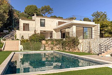 A large house with a swimming pool in front of it