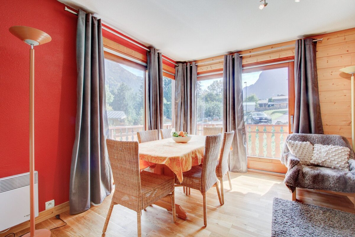 A dining room with a table and chairs and a lamp