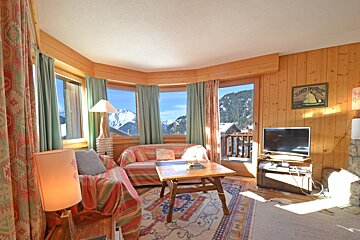 A living room with a couch and a television and a sign on the wall that says alfred bauer