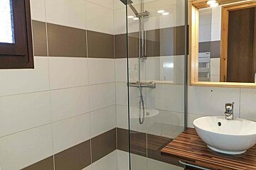 A bathroom with a sink and a walk in shower