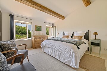A bedroom with a bed and a chair and the words made in provence on the wall