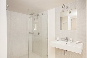 A bathroom with a sink and a walk in shower