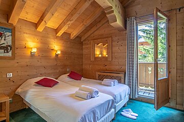 A bedroom with two beds and a picture of a ski resort