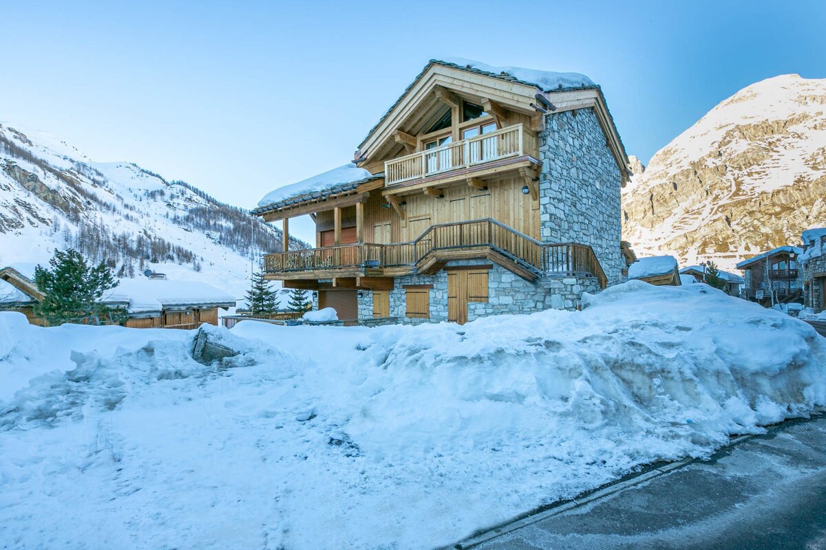 A snowy house with a mountain in the background