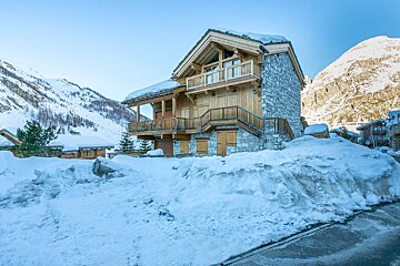 A snowy house with a mountain in the background