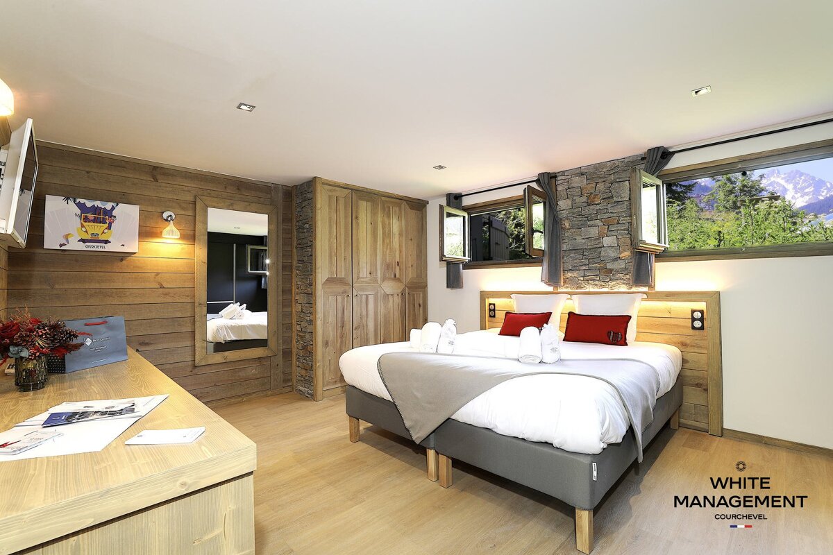 A bedroom with a bed and a mirror on the wall