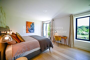 A bedroom with a bed a desk and a painting of a gorilla on the wall