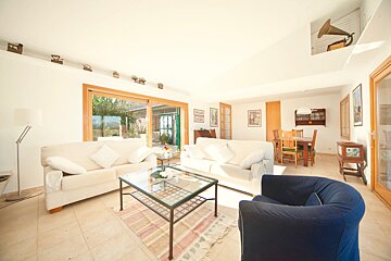 A living room with two white couches and a blue chair